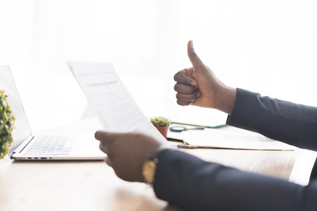 Client approving signed documents with a thumbs up