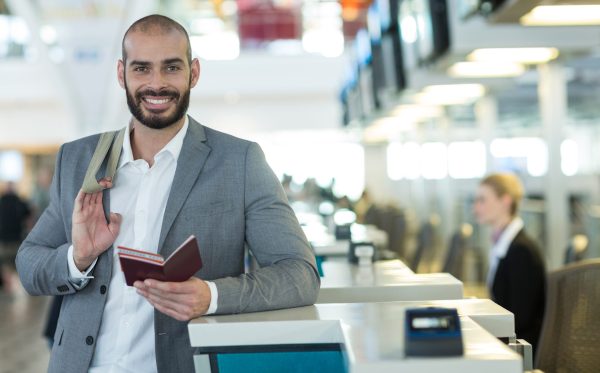 Traveller holding a passport at an airport counter